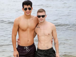 Los hombres homosexuales que se divierten en la orilla y luego en la habitación del hotel