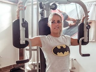 Atleta teenager bionda del corpo perfetto scopa in palestra